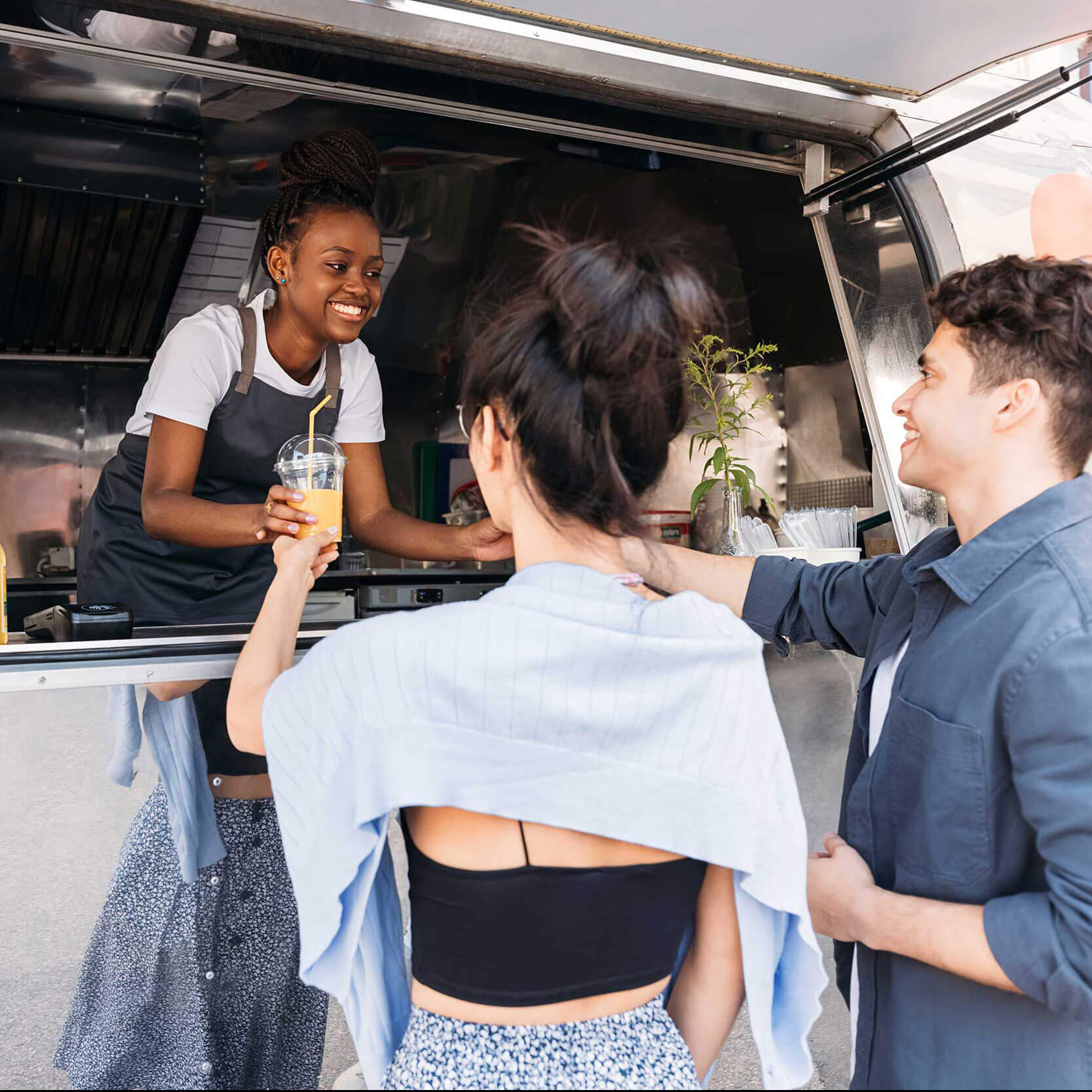 shutterstock_2035672016-mobile Woman serving drinks to people outside of food truck