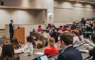 Image of Corby Kummer standing at a lectern in an auditorium filled with participants.