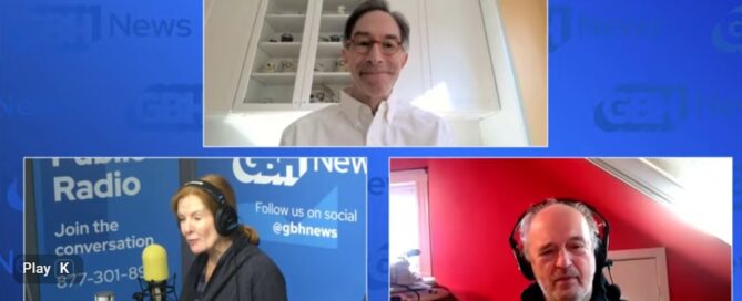 Screenshot of a YouTube livestream of Boston Public Radio. The background is light blue. The top center image is of Corby Kummer, executive director of Food & Society (he is wearing a white button down shirt and behind him is a glass fronted cabinet and coral colored walls). The botton left is Margery, a host of Boston Public Radio in the studio, seated before a microphone. The Boston Public Radio logos are featured behind her. Co-host Jim is in the lower right wearing headphones and seated in a room with red walls.