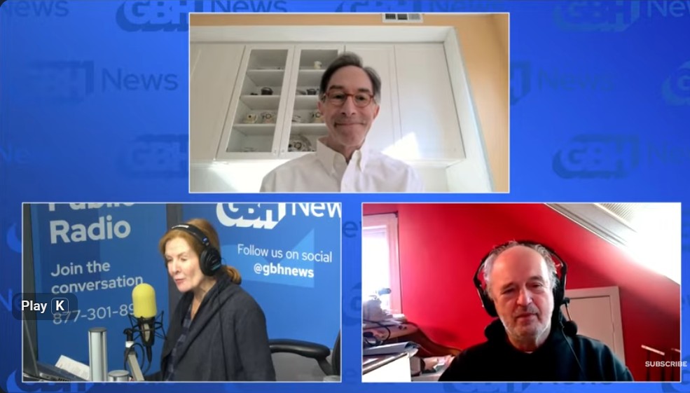 Screenshot of a YouTube livestream of Boston Public Radio. The background is light blue. The top center image is of Corby Kummer, executive director of Food & Society (he is wearing a white button down shirt and behind him is a glass fronted cabinet and coral colored walls). The botton left is Margery, a host of Boston Public Radio in the studio, seated before a microphone. The Boston Public Radio logos are featured behind her. Co-host Jim is in the lower right wearing headphones and seated in a room with red walls.